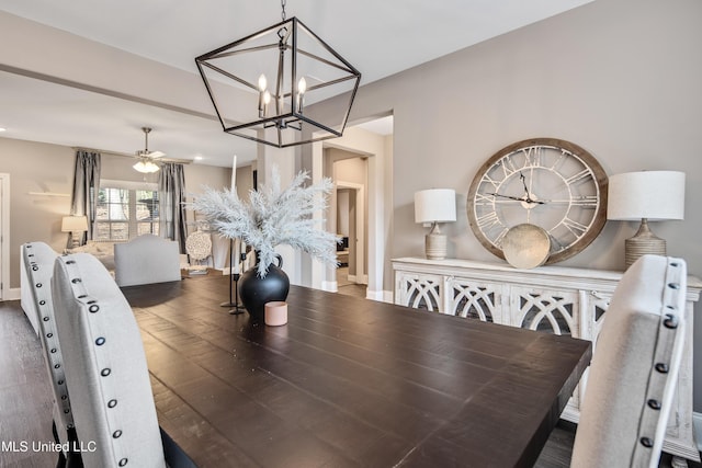 dining room with ceiling fan with notable chandelier, hardwood / wood-style floors, and baseboards