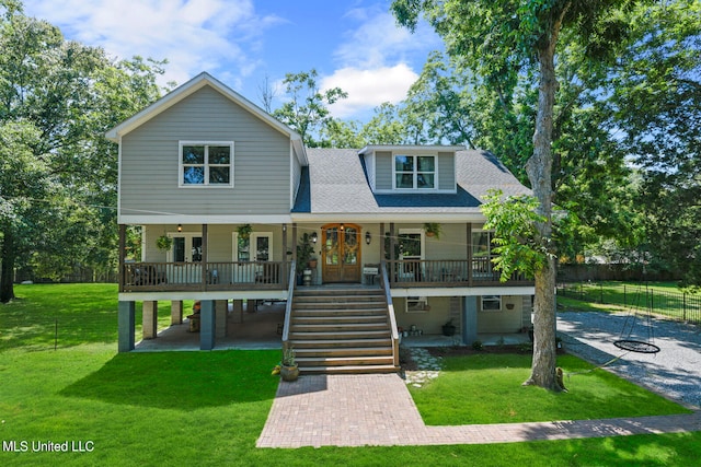 view of front of house with a front yard, a garage, and a porch