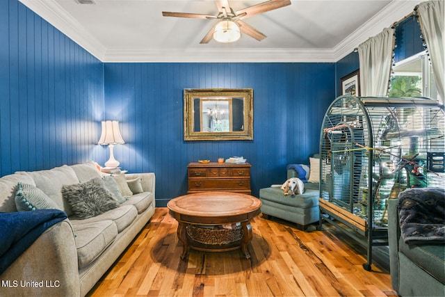 living area with ornamental molding, hardwood / wood-style flooring, and ceiling fan