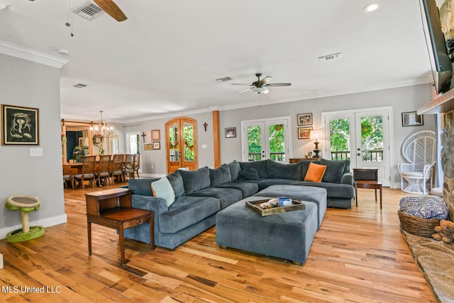 living room featuring french doors, light hardwood / wood-style flooring, crown molding, and ceiling fan with notable chandelier