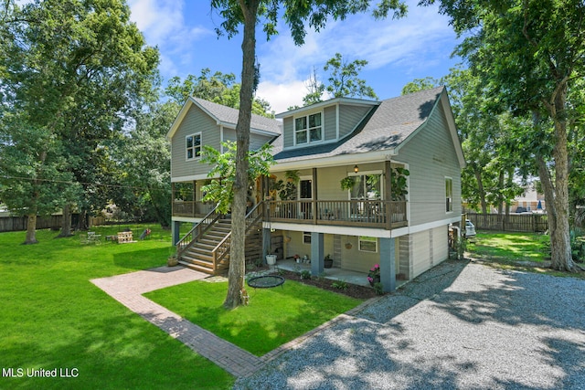 view of front of home featuring a porch, a front yard, and a garage