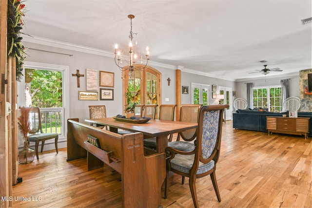 dining area with light hardwood / wood-style flooring, ornamental molding, and ceiling fan with notable chandelier