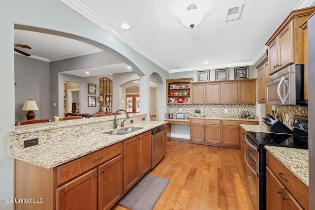 kitchen featuring visible vents, a sink, arched walkways, stainless steel appliances, and open shelves