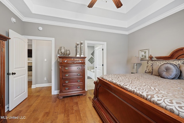 bedroom featuring light wood finished floors, a ceiling fan, a raised ceiling, and baseboards