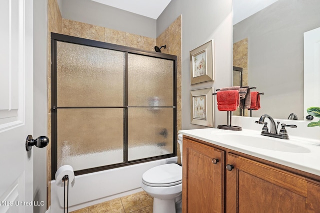 bathroom with combined bath / shower with glass door, toilet, vanity, and tile patterned flooring