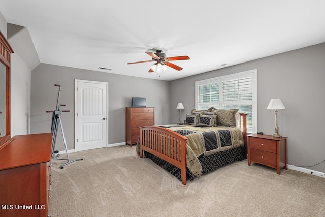 bedroom featuring a ceiling fan, light colored carpet, visible vents, and baseboards