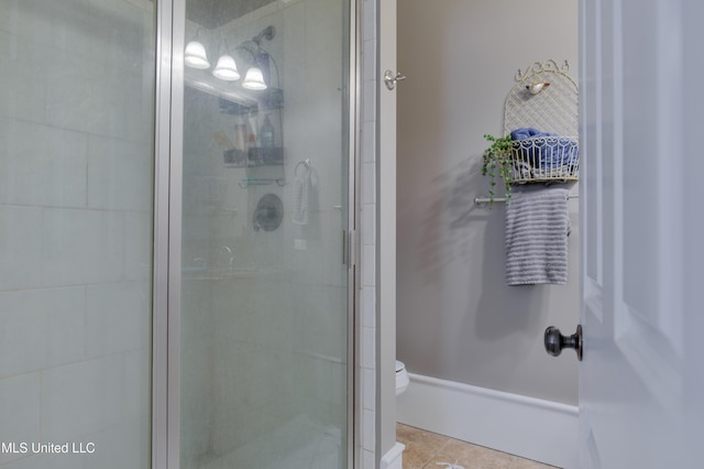 bathroom with tile patterned flooring, an enclosed shower, and toilet