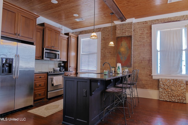 kitchen featuring pendant lighting, stainless steel appliances, a wealth of natural light, and dark wood-type flooring