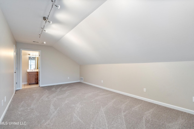 bonus room featuring light colored carpet and lofted ceiling