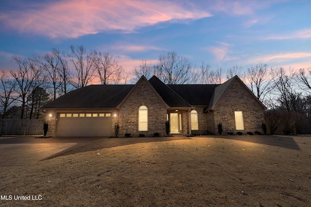 view of front of property with a garage and a lawn