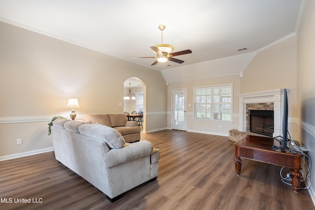 living room with plenty of natural light, ornamental molding, dark hardwood / wood-style floors, and vaulted ceiling