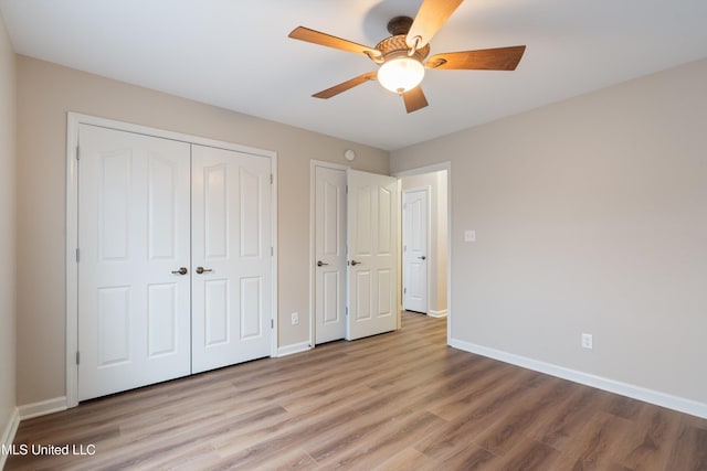 unfurnished bedroom featuring ceiling fan, light hardwood / wood-style floors, and a closet