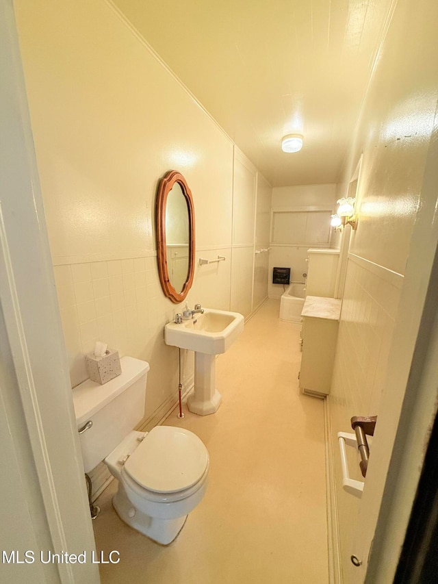 bathroom with toilet and tile walls