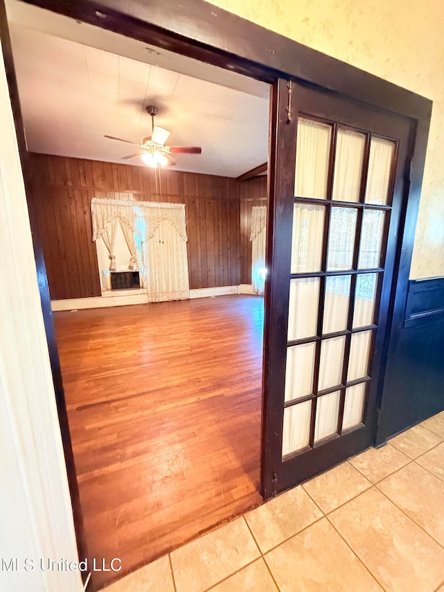 interior space featuring wood walls, wood-type flooring, and ceiling fan