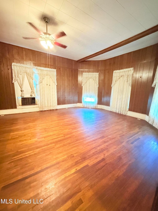 unfurnished living room featuring hardwood / wood-style floors and wooden walls