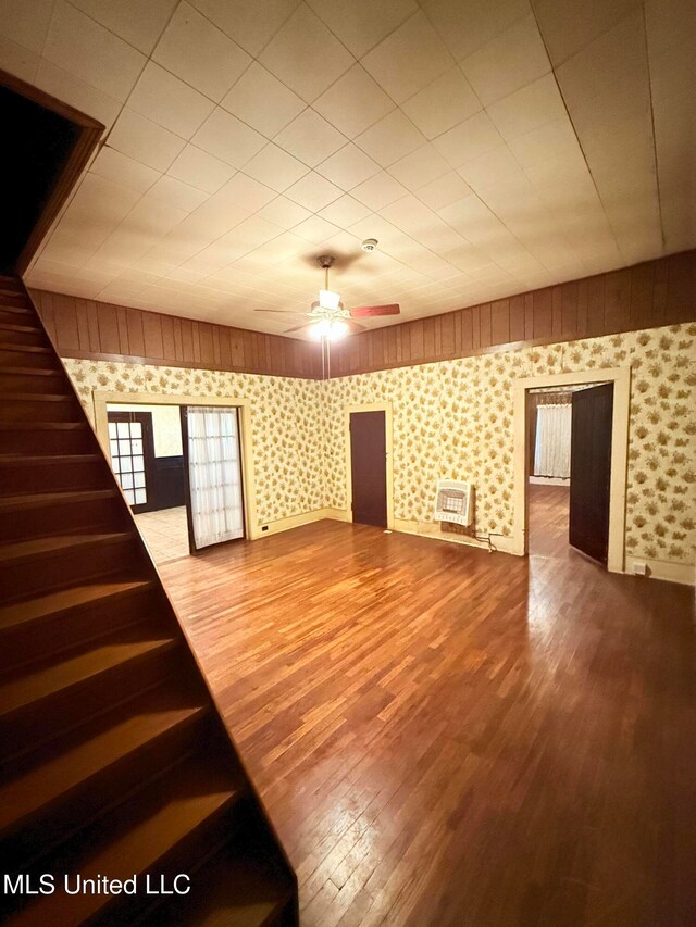 interior space featuring heating unit, wood-type flooring, and ceiling fan