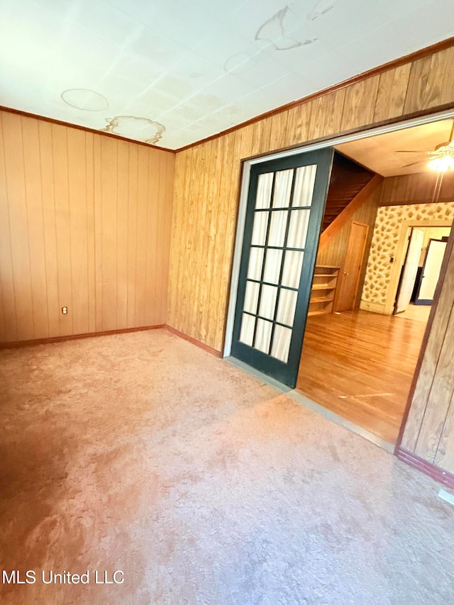 spare room with wooden walls, wood-type flooring, lofted ceiling, and ceiling fan