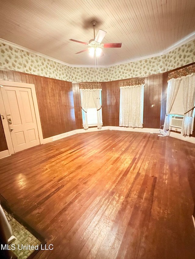 empty room featuring cooling unit, wood-type flooring, wooden walls, wooden ceiling, and ceiling fan