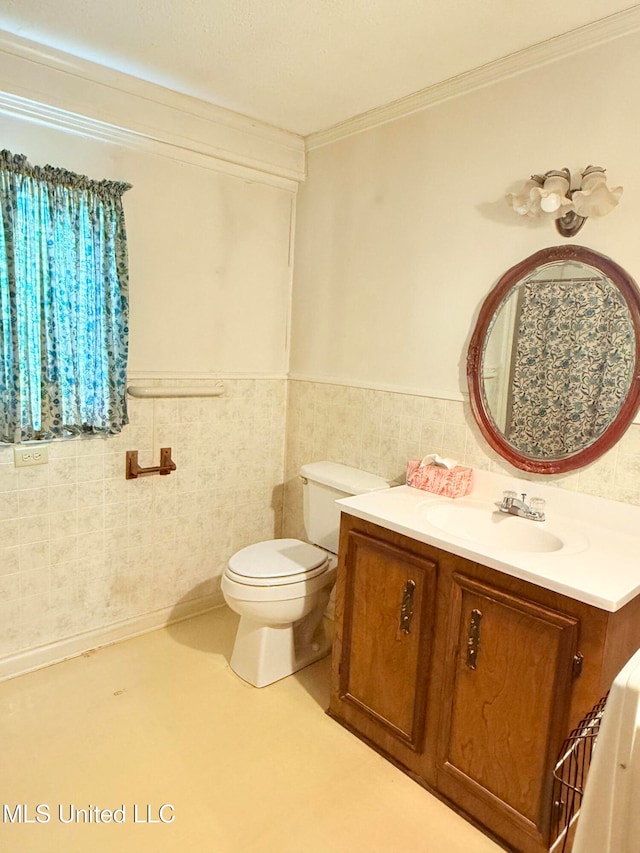 bathroom featuring vanity, crown molding, toilet, and tile walls