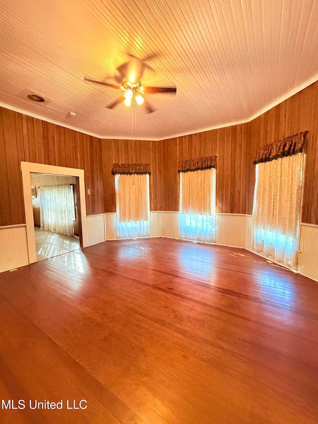 unfurnished room featuring crown molding, wood walls, hardwood / wood-style floors, wooden ceiling, and ceiling fan