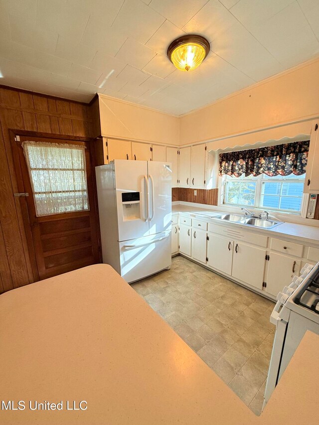 kitchen featuring white cabinets, plenty of natural light, sink, and white appliances