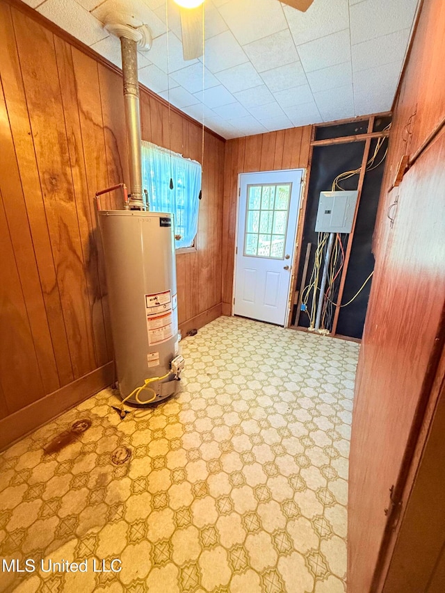 interior space featuring wooden walls and gas water heater