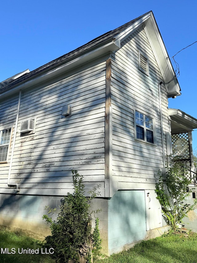 view of property exterior featuring an AC wall unit