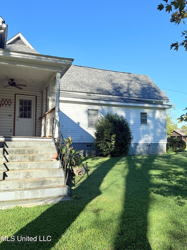 view of home's exterior featuring a lawn and ceiling fan