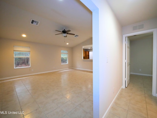 spare room with light tile patterned flooring, visible vents, and a ceiling fan