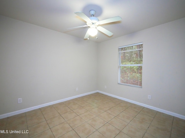 unfurnished room with a ceiling fan and baseboards