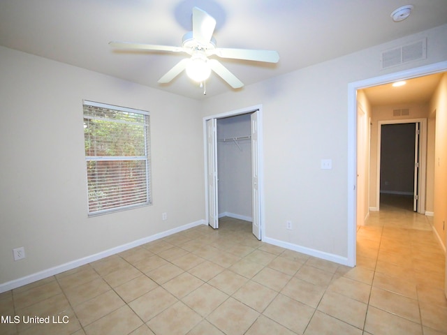 unfurnished bedroom featuring light tile patterned floors, baseboards, visible vents, and a closet