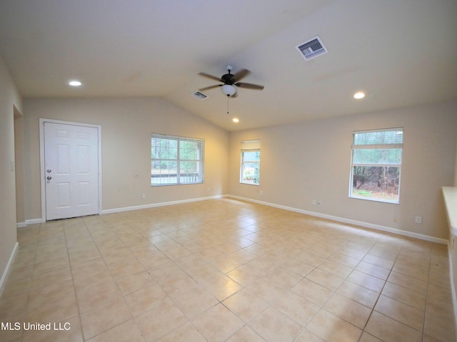 empty room featuring lofted ceiling, ceiling fan, visible vents, and baseboards