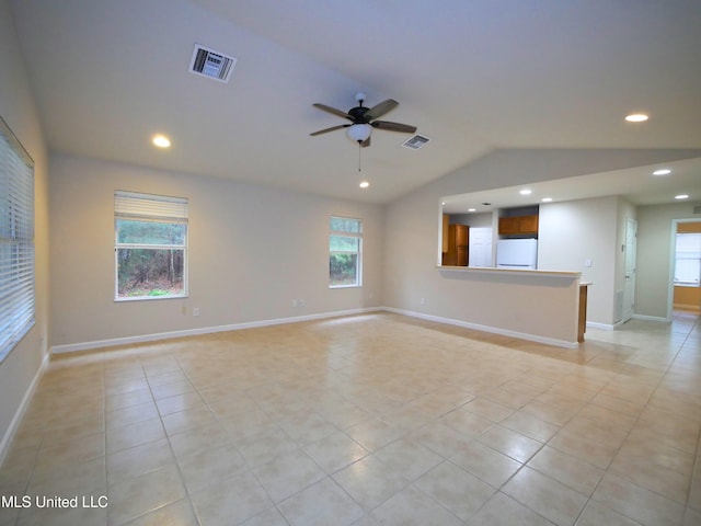 empty room with a wealth of natural light, visible vents, and vaulted ceiling