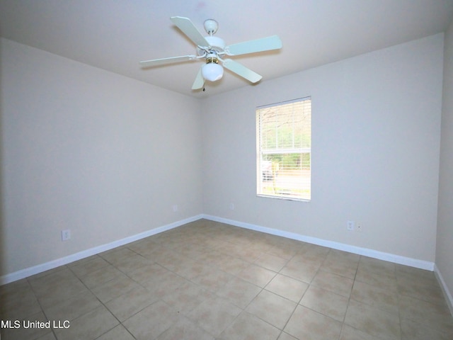 spare room featuring light tile patterned floors, ceiling fan, and baseboards