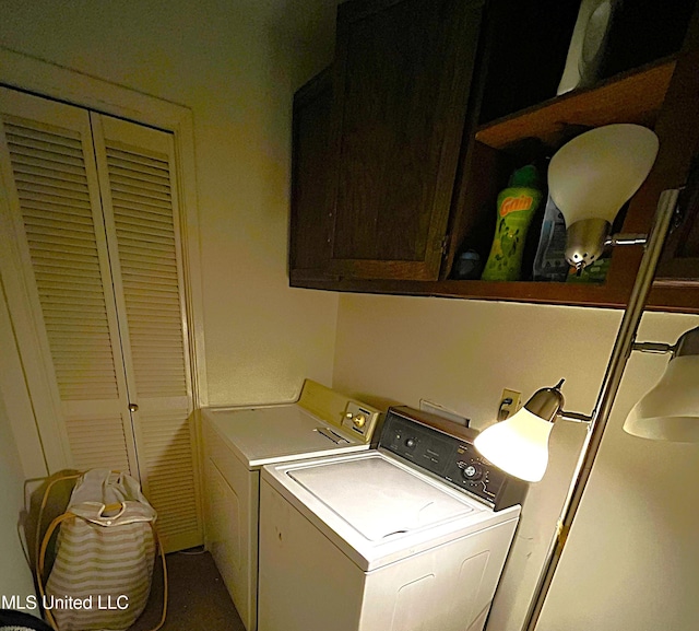 clothes washing area with washing machine and dryer and cabinets