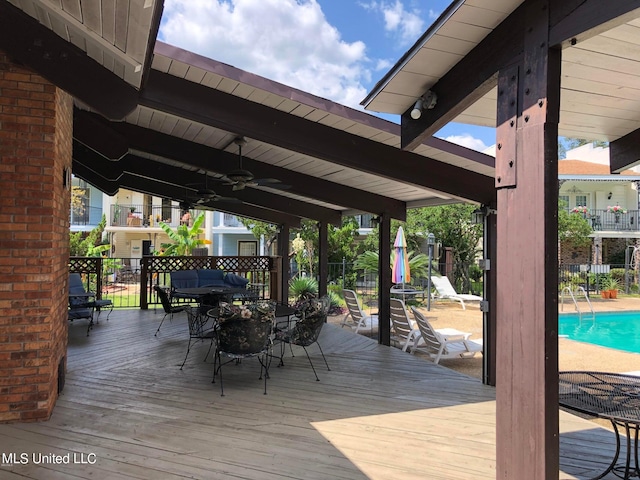 wooden deck featuring ceiling fan and a fenced in pool