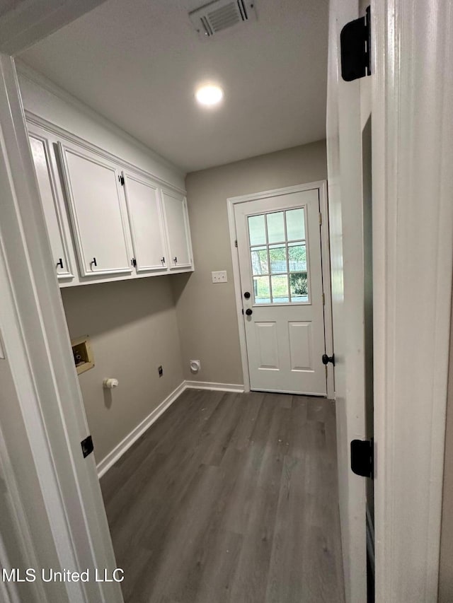 laundry area with hookup for a washing machine, dark hardwood / wood-style flooring, gas dryer hookup, electric dryer hookup, and cabinets