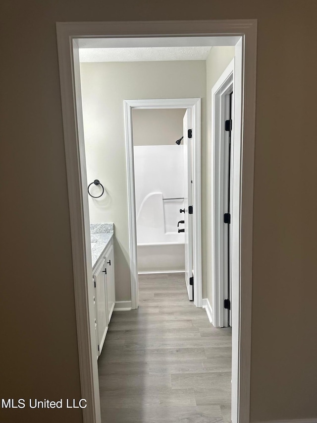 bathroom featuring vanity, hardwood / wood-style flooring, and a bathtub