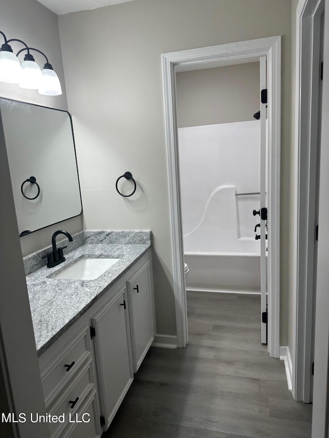 bathroom featuring vanity, hardwood / wood-style floors, and toilet