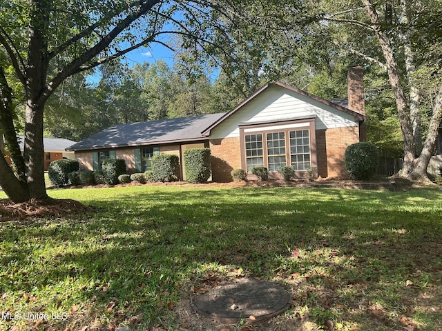 single story home featuring a front lawn, a chimney, and brick siding