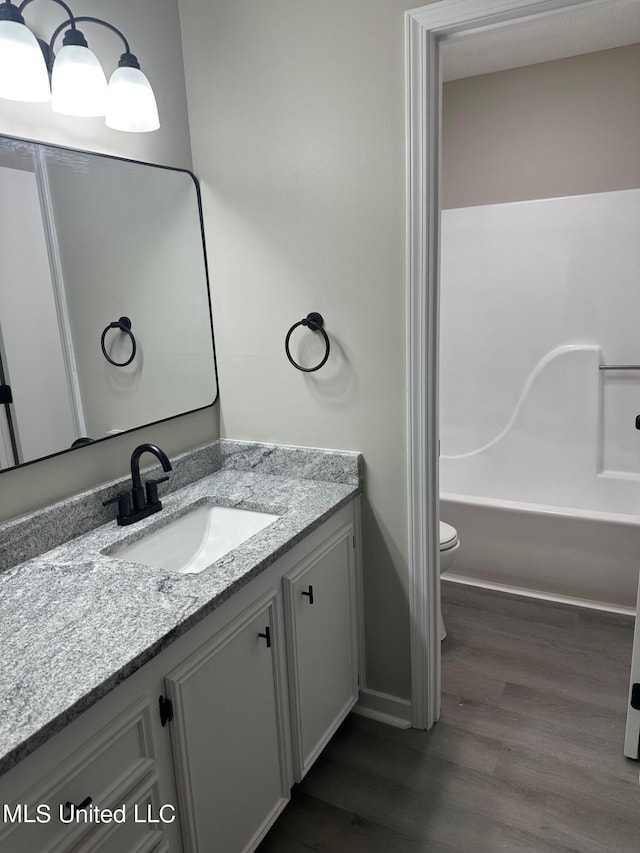 bathroom featuring vanity, hardwood / wood-style flooring, and toilet