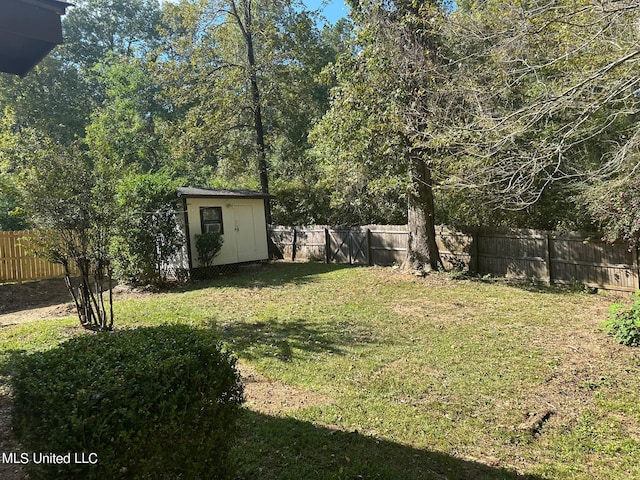 view of yard with a storage shed, an outbuilding, and a fenced backyard