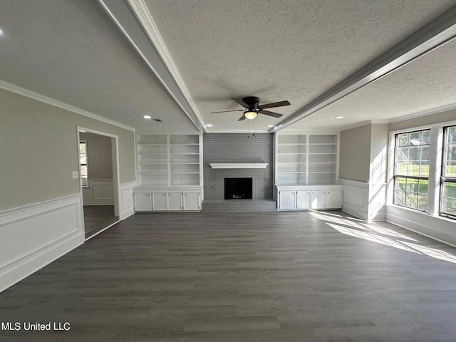 unfurnished living room with built in features, a textured ceiling, a brick fireplace, and dark hardwood / wood-style floors