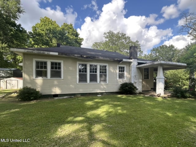 2305 Grenada Blvd, Greenwood, MS 38930 - rear view of house featuring a shed, a chimney, and a yard