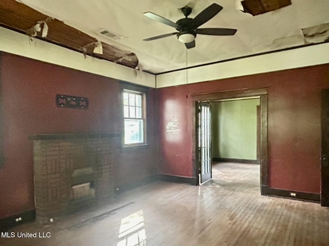 2305 Grenada Blvd, Greenwood, MS 38930 - empty room with a fireplace, a ceiling fan, and wood finished floors