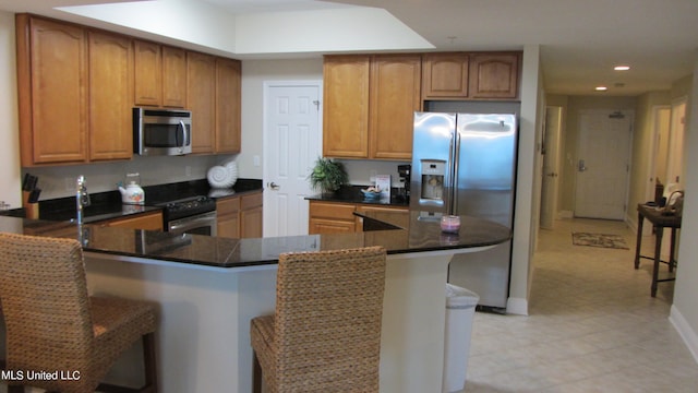 kitchen with a breakfast bar area and appliances with stainless steel finishes