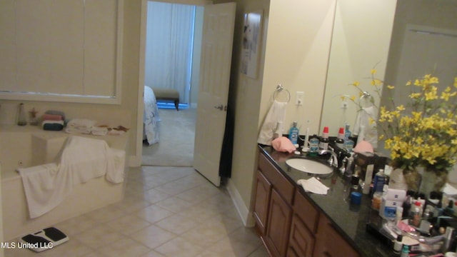 bathroom with a bathtub, vanity, and tile patterned floors