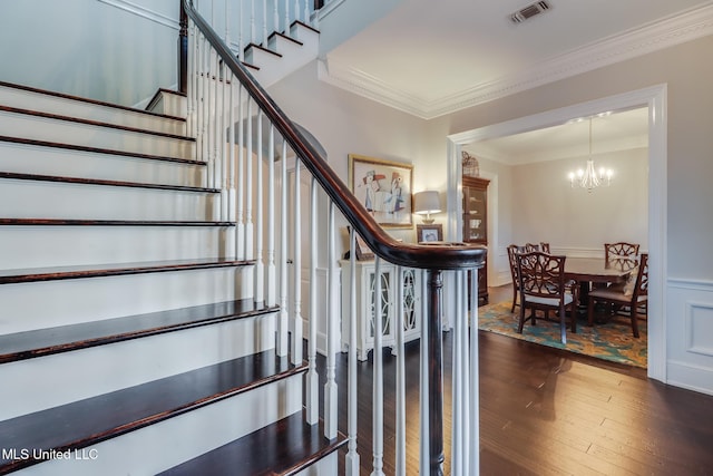 2011 Pointe Clear Dr, Biloxi, MS 39531 - stairway featuring crown molding, hardwood / wood-style flooring, a chandelier, a wainscoted wall, and a decorative wall