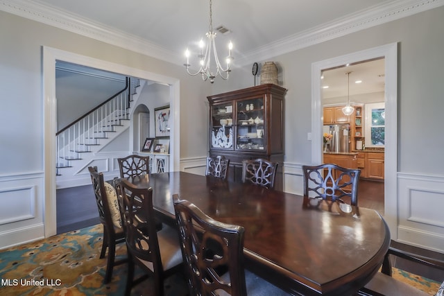 2011 Pointe Clear Dr, Biloxi, MS 39531 - dining space featuring a decorative wall, stairs, wainscoting, dark wood-type flooring, and a chandelier