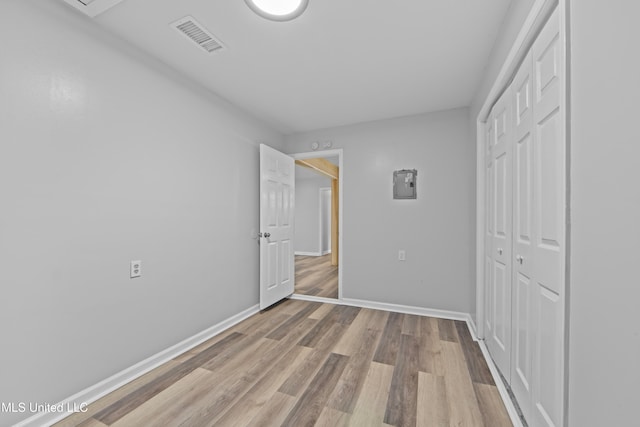 unfurnished bedroom featuring light hardwood / wood-style floors and a closet